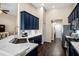 Modern kitchen featuring navy cabinets, marble countertops, and stainless steel appliances at 1418 Hurley Pond Ln, Valrico, FL 33596