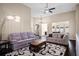 Comfortable living room featuring a ceiling fan and elegant lighting fixture above the sofas and coffee table at 1418 Hurley Pond Ln, Valrico, FL 33596