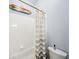 Bright bathroom featuring a white tiled shower with striped curtain, and fun surfboard decor at 15930 Sorawater Dr, Lithia, FL 33547