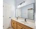 Bathroom boasting double sinks, a large mirror and wood cabinets at 15930 Sorawater Dr, Lithia, FL 33547