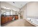 Large bathroom with dual vanities, a glass shower, a garden tub, and tile floors at 15930 Sorawater Dr, Lithia, FL 33547