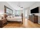 Spacious bedroom with wooden floors, TV, and a sitting area near the window at 15930 Sorawater Dr, Lithia, FL 33547
