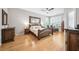 Bright bedroom with hardwood floors, a decorative mirror, and natural light from large windows at 15930 Sorawater Dr, Lithia, FL 33547