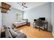 A cozy bedroom features a comfortable bed, bamboo flooring, window, sofa, and ceiling fan at 15930 Sorawater Dr, Lithia, FL 33547