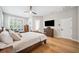 Bright bedroom featuring hardwood floors, large windows, a TV, and a comfortable seating area at 15930 Sorawater Dr, Lithia, FL 33547