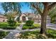 Charming home showcasing a manicured lawn, symmetrical shrubbery, and a welcoming arched entryway at 15930 Sorawater Dr, Lithia, FL 33547