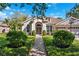 Inviting front exterior with a neatly landscaped yard, a symmetrical design, and a classic arched doorway at 15930 Sorawater Dr, Lithia, FL 33547