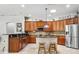 Bright kitchen includes stainless steel appliances, island with seating, granite countertops, and wood cabinetry at 15930 Sorawater Dr, Lithia, FL 33547