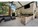 Relaxing outdoor kitchen with a built-in grill, bar, and a cozy seating area for enjoying outdoor meals at 15930 Sorawater Dr, Lithia, FL 33547