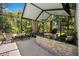 Well-equipped outdoor kitchen with granite counters, a built-in grill, and comfortable seating area at 15930 Sorawater Dr, Lithia, FL 33547
