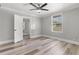 Bright bedroom offers a sunlit window, wood-look floors, and neutral gray walls at 1600 E Hanna Ave, Tampa, FL 33610