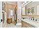 Bathroom featuring a vanity with granite countertop, decorative mirror, and walk-in shower at 16608 Meadow Cove St, Tampa, FL 33624
