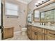 Well-appointed bathroom with granite countertop, wood cabinetry, and a framed mirror at 16608 Meadow Cove St, Tampa, FL 33624