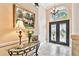 Bright foyer featuring tile floors, a glass-topped console table, and a decorative front door at 16608 Meadow Cove St, Tampa, FL 33624