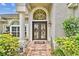 Welcoming front entrance features double doors, decorative glass, manicured shrubs, and a brick pathway at 16608 Meadow Cove St, Tampa, FL 33624