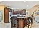 Elegant kitchen features granite countertops, dark wood cabinetry, and stainless steel appliances at 16608 Meadow Cove St, Tampa, FL 33624