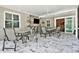 Covered patio with tile flooring, ceiling fan, bar area, and multiple seating arrangements at 16608 Meadow Cove St, Tampa, FL 33624
