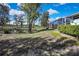 Wide open back yard with green grass, scattered trees and an enclosed pool at 17364 Mediterranean Cir, Weeki Wachee, FL 34614