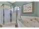 Bathroom featuring tiled glass shower and a corner soaking tub with chrome fixtures at 17364 Mediterranean Cir, Weeki Wachee, FL 34614