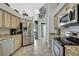 Updated kitchen featuring stainless appliances, stone countertops, and light wood cabinetry with tile floors at 17364 Mediterranean Cir, Weeki Wachee, FL 34614