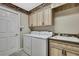 Bright laundry room featuring a washer, dryer, sink, and cabinets for ample storage space at 17364 Mediterranean Cir, Weeki Wachee, FL 34614