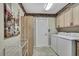 Spacious laundry room offering washer, dryer, cabinets and shelving for organized storage solutions at 17364 Mediterranean Cir, Weeki Wachee, FL 34614