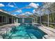 Enclosed pool features a beautiful deck, turquoise water, and view of the home at 17364 Mediterranean Cir, Weeki Wachee, FL 34614