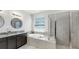 Relaxing bathroom showcasing a soaking tub, walk-in shower, and vanity with granite countertops at 17740 Bright Wheat Dr, Lithia, FL 33547