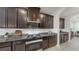 Modern kitchen features stainless appliances, granite countertops, and dark wood cabinets at 17740 Bright Wheat Dr, Lithia, FL 33547