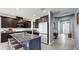 Modern kitchen features stainless appliances, granite countertops, a blue island, and opens to the entryway at 17740 Bright Wheat Dr, Lithia, FL 33547