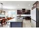 Bright kitchen features granite counters, an island with a sink, stainless appliances, and dark cabinetry at 17740 Bright Wheat Dr, Lithia, FL 33547
