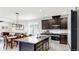 Kitchen with center island, dark cabinets, stainless appliances and a breakfast table with a pendant light at 17740 Bright Wheat Dr, Lithia, FL 33547