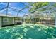 Enclosed patio features turf and lounge seating, overlooking a backyard and hot tub at 1968 Rolling Green Cir, Sarasota, FL 34240