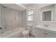 Clean bathroom with a shower-tub combo, toilet and sink with marble-style tile at 1968 Rolling Green Cir, Sarasota, FL 34240