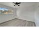 Bright bedroom with a ceiling fan and a large window overlooking a tree-lined neighborhood at 1968 Rolling Green Cir, Sarasota, FL 34240