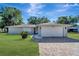 Charming single-story home featuring a well-manicured lawn and a brick-paved driveway leading to an attached two-car garage at 1968 Rolling Green Cir, Sarasota, FL 34240