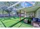 Screened-in patio with artificial turf, comfortable seating, and an adjacent hot tub area at 1968 Rolling Green Cir, Sarasota, FL 34240
