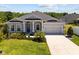 Charming single Gathering home with manicured lawn, landscaping, palm tree and a long driveway at 2106 Alimara Ct, Odessa, FL 33556