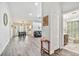 Bright, open-concept living space with hardwood floors, dining area, comfortable seating, and a bathroom to the side at 2291 Americus W Blvd # 41, Clearwater, FL 33763