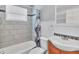 Bathroom with shower over tub, decorative tile, and wood-look cabinets at 3045 Stratford Dr, Largo, FL 33771