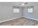 Bright bedroom with two windows, grey walls, wood-look floors, and ceiling fan at 3045 Stratford Dr, Largo, FL 33771