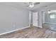 Bedroom with wood-look floors, ceiling fan, sliding mirror closet, and grey paint at 3045 Stratford Dr, Largo, FL 33771