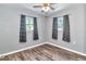 Bedroom features wood-look flooring, gray walls and matching dark curtains at 3045 Stratford Dr, Largo, FL 33771