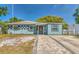 Charming single-story home featuring a colorful facade, brick walkway, and well-maintained landscaping at 3045 Stratford Dr, Largo, FL 33771