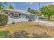 Charming single-story home featuring a colorful facade, brick walkway, and well-maintained landscaping at 3045 Stratford Dr, Largo, FL 33771