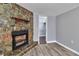 Stone fireplace with mantel and hearth, plus wood-look floors and a closet, create a cozy room at 3045 Stratford Dr, Largo, FL 33771
