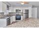 Updated kitchen features stainless steel appliances, granite counters, stylish backsplash, and white cabinetry at 3045 Stratford Dr, Largo, FL 33771