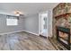Cozy living room with rustic stone fireplace, wood-look floors, and natural light at 3045 Stratford Dr, Largo, FL 33771