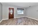 Living room features wood-look floors, neutral paint, and a lovely front door with glass insert at 3045 Stratford Dr, Largo, FL 33771