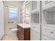 Bright bathroom featuring modern vanity, storage cabinets, tile floors, and updated fixtures at 3214 W Rogers Ave, Tampa, FL 33611